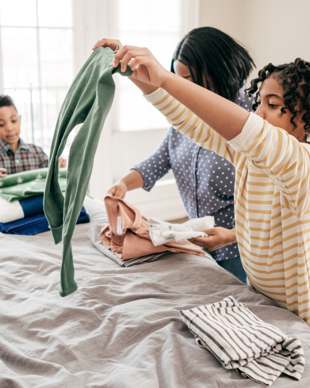A mother and children folding laundry together